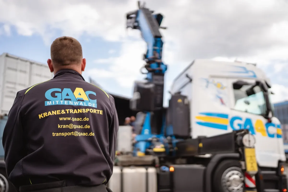 GAAC-Kollege im Firmenshirt vor dem Ladekran