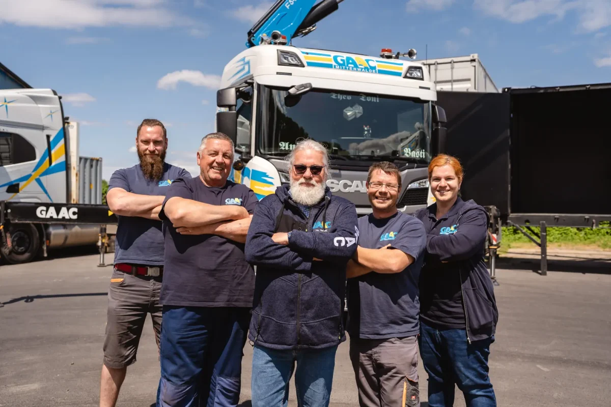 Fünf GAAC-Kollegen vor einem Scania auf dem Betriebshof