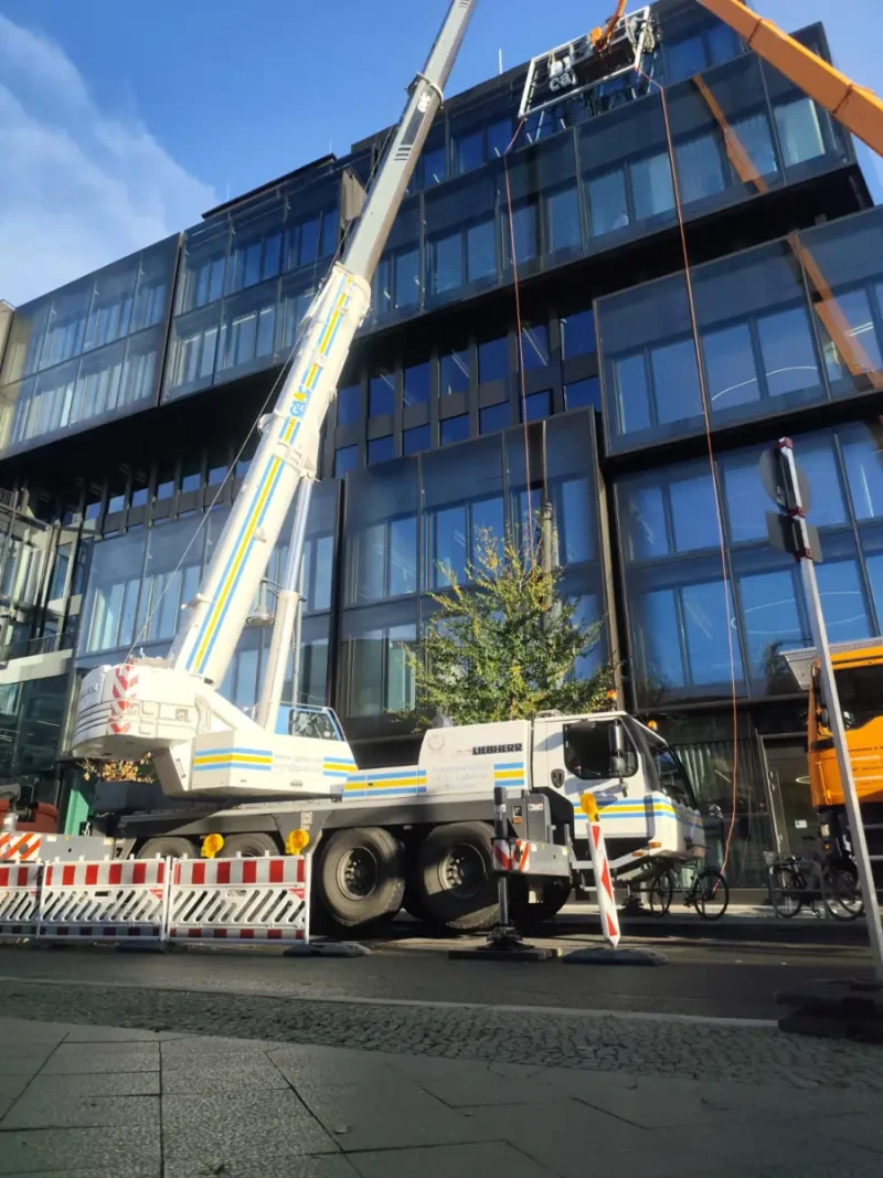 Autokran vor der Glasfassade